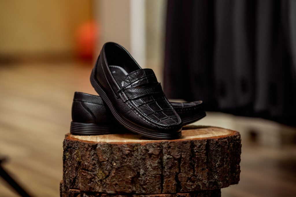 Black vintage loafers on a chopped tree trunk