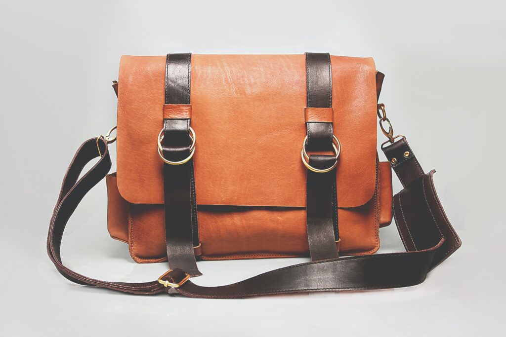 a brown leather messenger bag with two straps.