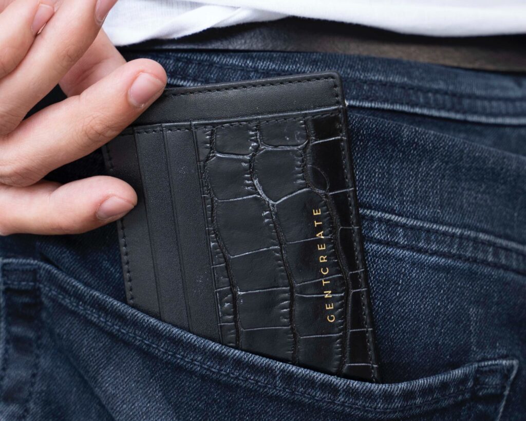 A black men's wallet in a jeans trouser pocket