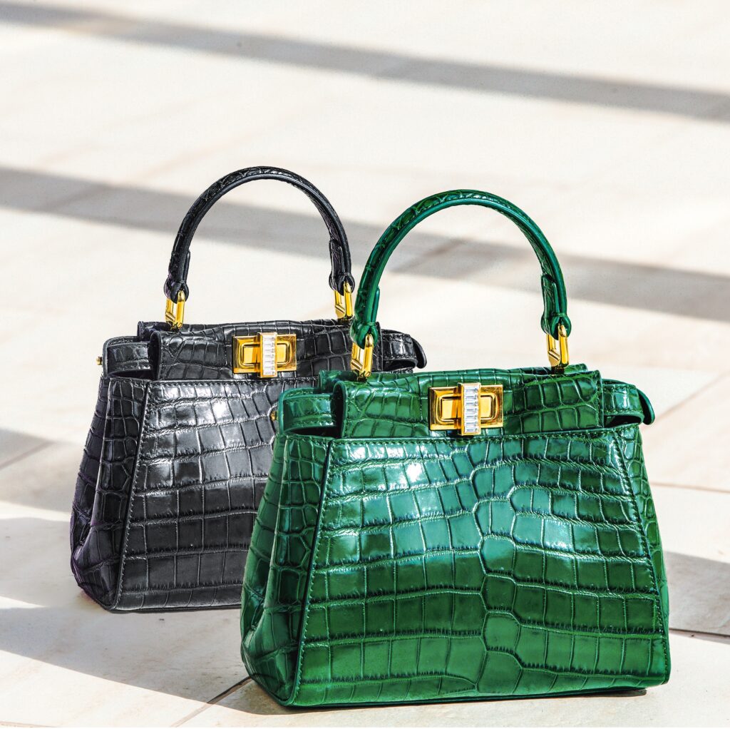 two green and black women purses on the ground.