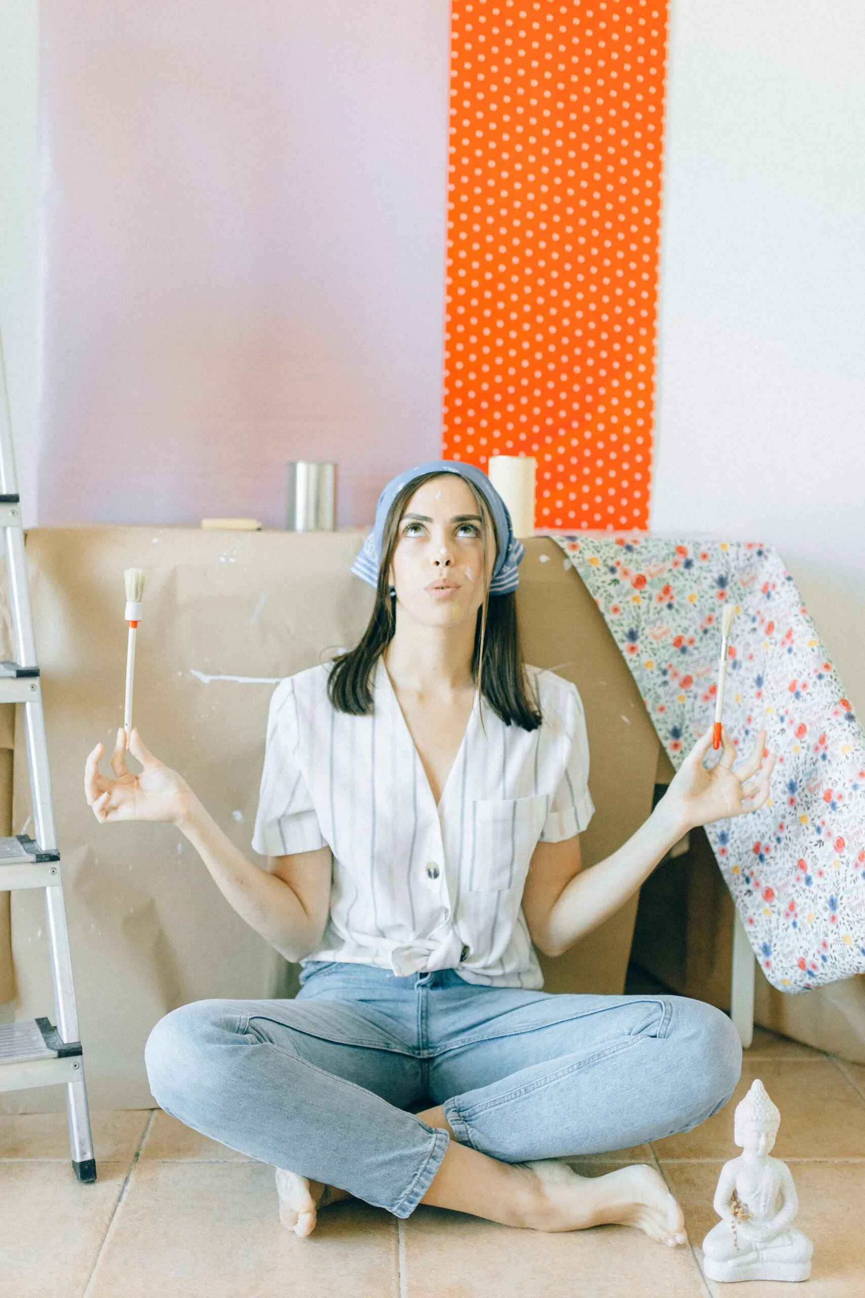 A woman doing yoga in the living room with a dotted wallpaper behind her