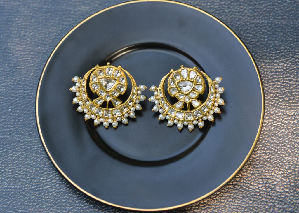 Diamond and gold earrings on a blue ceramic plate