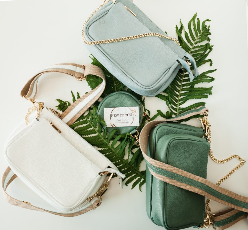 a bunch of handbags on top of a shelf.