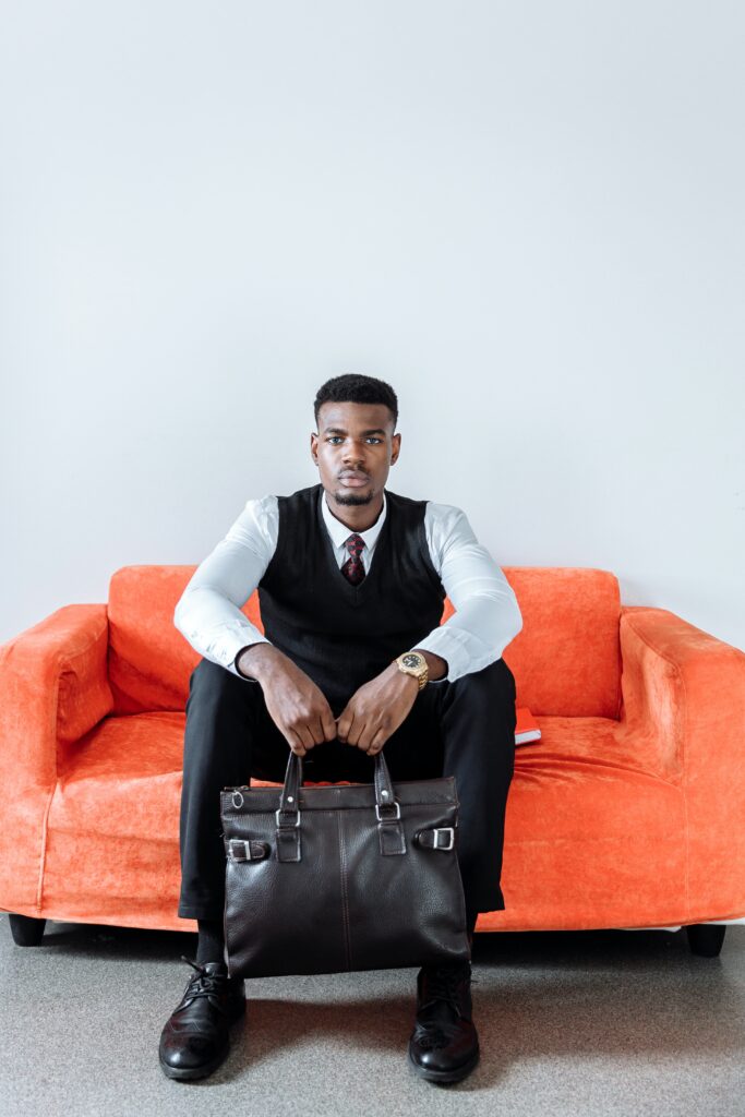 a man sitting on a couch holding a briefcase